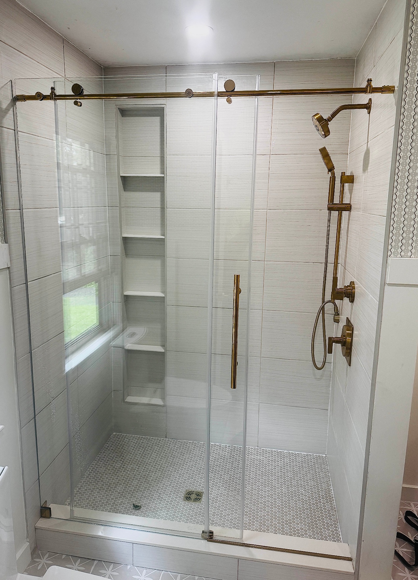 Frameless glass shower with gold barn-door slider